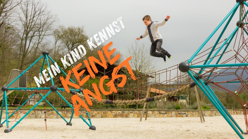 Ein Kind springt mutig von einem Klettergerüst in einem Spielplatz, umgeben von Bäumen und einem sandigen Boden. Der Text 'Mein Kind kennt keine Angst' ist prominent sichtbar.